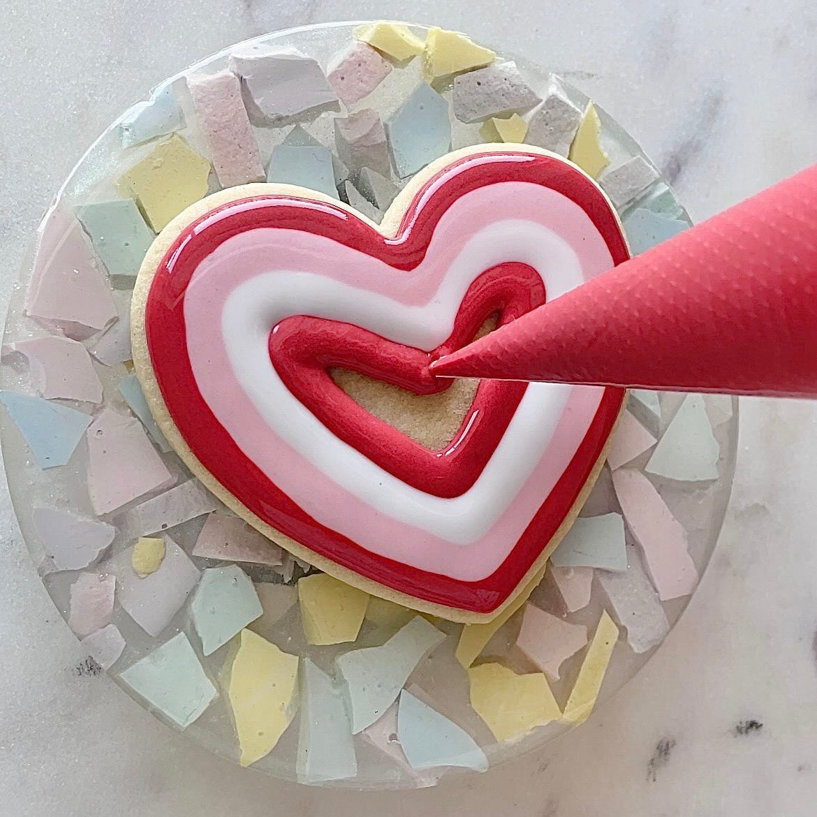 Cake Decorating turntable with a heart shaped cookie on it.